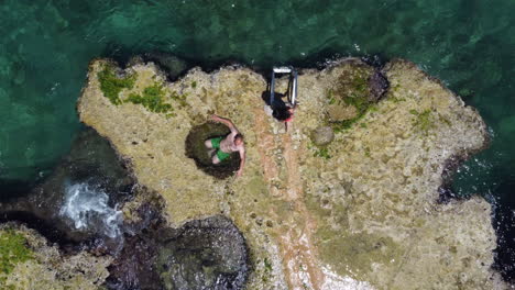 Aerial:-tourist-sun-bathing-in-natural-sea-pool-at-a-waterfront-resort-in-Enfeh---drone-ascending-shot