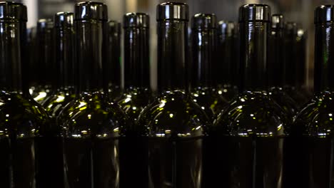 Empty-bottles-moving-along-on-a-conveyor-belt-to-be-filled-and-labeled-for-sale-and-distribution---isolated