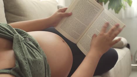 A-young-pregnant-woman-reads-a-good-book-in-a-relaxed-way