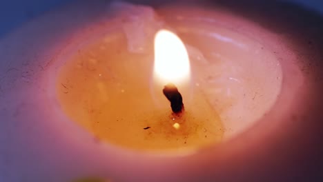 Large-thick-candlelit-and-burn-on-a-black-background-close-up