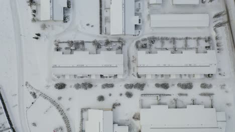 Top-down-aerial-forward-moving-view-of-row-house-residential-area-in-winter-time-when-everything-is-covered-in-snow