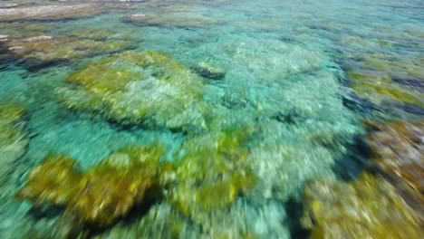 Flying-low-above-clear-turquoise-sea-water-in-Greece,-idyllic-Elafonisi-beach-lagoon