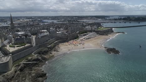 Aerial-footage-of-Saint-Malo,-the-beach,-the-city,-the-sea-and-the-Wall-of-Saint-Malo