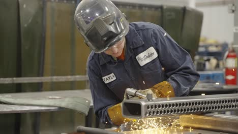 Slow-mo,-blue-collar-worker-welding-piece-of-metal-in-workshop