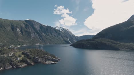 High-voltage-power-lines-crossing-across-fjord-in-Valldal-in-Norway,-aerial-view