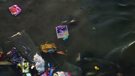Verschmutzte-Wasseroberfläche-Mit-Schwimmenden-Kunststoffen-Und-Anderem-Müll-In-Der-Gemeinde-Son-Hai,-Vietnam
