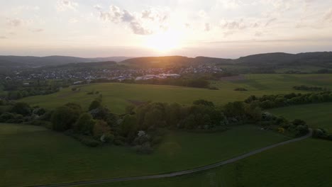 Aerial-slider-view-of-a-vibrant-sunset-over-European-countryside-during-spring
