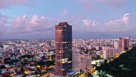Aerial-view-around-the-Anacaona-27-tower,-sunny-evening-in-Mirador-Del-Sur,-Dominican-Republic---orbit,-drone-shot