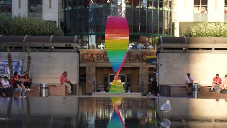 Canary-Wharf,-London,-England,-Juni-2022,-Stolz-Tribut-Skulptur-In-Zeitlupe,-Die-Sich-Am-Cabot-Square-Brunnen-Dreht,-Wobei-Die-Spiegelung-über-Das-Wasser-Zurückgespielt-Wird
