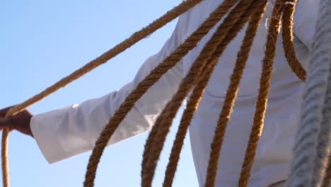 Detail-of-traditionally-dressed-man-preparing-ropes-for-a-boat-ride-in-Aswan,-Egypt