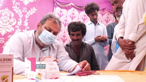 Aid-Doctor-Taking-Down-Notes-From-Local-Refugee-During-Flood-Relief-In-Pakistan