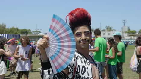 A-gay-having-red-colored-hair-participated-in-pride-parade-and-posing-in-front-of-camera-with-a-blower-in-his-hand