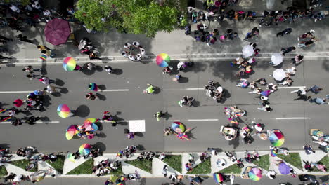aerial-drone-shot-of-many-people-waving-the-pride-flag-in-pride-parade-reforma-avenue,-mexico-city
