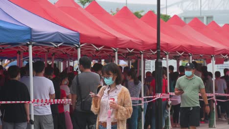 People-queue-in-line-to-receive-PCR-tests-for-coronavirus-from-a-Community-Testing-Centre-truck-to-tackle-the-spread-of-the-virus-and-a-pandemic-wave-near-Hong-Kong's-financial-district