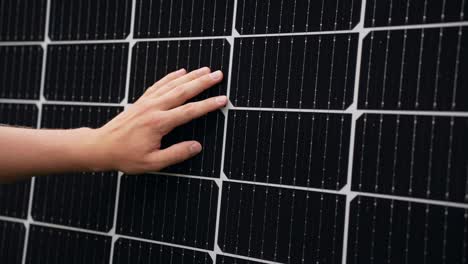 Hand-inspecting-efficient-solar-panel,-touching-cells,-closeup,-static,-day