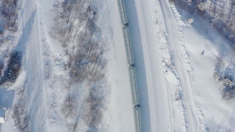 Eine-Vogelperspektive-Auf-Einen-Verschneiten-Zug,-Der-Durch-Die-Wälder-Im-Kanadischen-Schild-Fährt