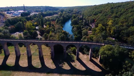 drone-flying-over-a-bridge-in-a-park,-quite-large-angle