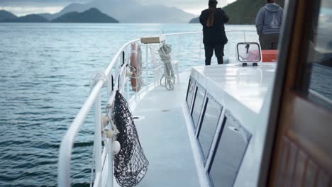 SLOWMO---People-standing-on-bow-deck-of-cruiser-talking-and-looking-at-landscape-in-Marlborough-Sounds,-New-Zealand