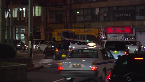 Static-shot-of-night-traffic-with-cars-and-taxis-in-Japanese-city