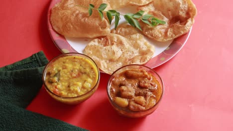 Rotación-Chole-Bhature-O-Curry-De-Garbanzos-Y-Puri-Frito-Servido-En-Vajilla-De-Terracota-Sobre-Fondo-Rojo