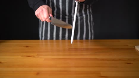 Slow-motion-of-a-man-Chef-using-various-techniques-to-sharpen-a-knife-with-his-hands,-using-a-professional-knife-and-a-diamond-sharpening-steel