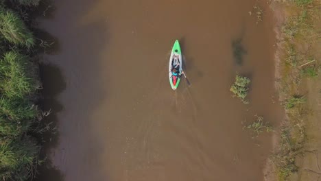 Birds-eye-view-of-a-man-kayaking-down-a-river
