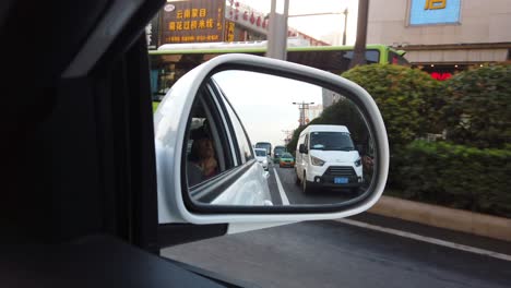 Xian,-China---August-2019-:-Car-mirror-view-of-the-traffic-on-busy-street-in-the-city-of-Xian-in-summer,-Shaanxi-Province