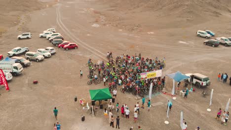 Filipino-mountain-bikers-at-the-starting-line-of-a-cycling-race-event-in-a-barren-area-with-mountains---AERIAL-CLOSE-UP