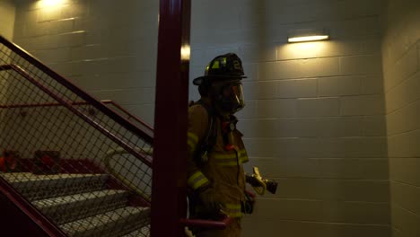 Firefighter-carries-fire-hose-during-a-firefighting-emergency-training-exercise