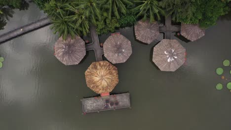 aerial-view-of-a-group-of-traditional-asian-hexagonal-shaped-buildings-built-over-a-lake-joined-to-each-other-and-the-shore-by-elevated-walkways