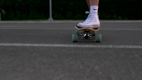 woman-ron-the-skate-on-asphalt,-low-angle,-tracking-close-up-shot