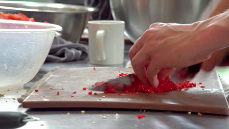 Slow-motion-slider-of-a-chef-finely-chopping-and-dicing-fresh-chilli-peppers