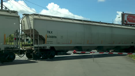 train-on-tracks-going-through-railroad-crossing