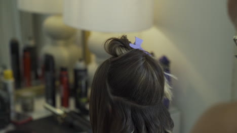 Hair-stylist-curling-bridal-hair-using-curling-iron