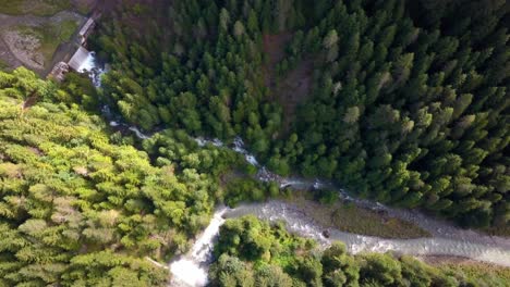 The-confluence-of-two-streams-in-the-Dolomite-mountains-of-northern-Italy,-Aerial-drone-pedestal-down-shot