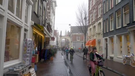 Cyclist-travelling-down-a-narrow-street-on-a-misty-day-in-staalstraat-near-Staalmeestersbrug