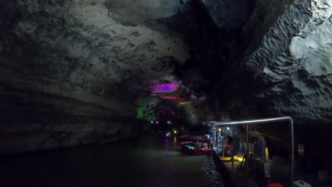 Tourist-boats-docked-on-the-shore-of-underwater-river-in-the-the-beautiful-Huanglong-Yellow-Dragon-Cave-called-also-the-Wonder-of-the-World`s-Caves,-Zhangjiajie,-Hunan-province,-China