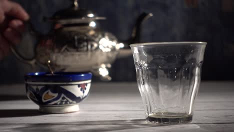 Cinemagraph-of-closeup-of-tea-pouring-into-a-glass-with-Moroccan-tea-set-and-mint