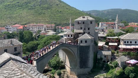 Gente-Caminando-Sobre-El-Viejo-Puente-En-Mostar-En-Un-Día-Soleado