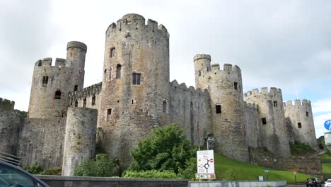 Medieval-landmark-historic-Conwy-Castle-Welsh-town-scene-traffic-passing-through-cityscape