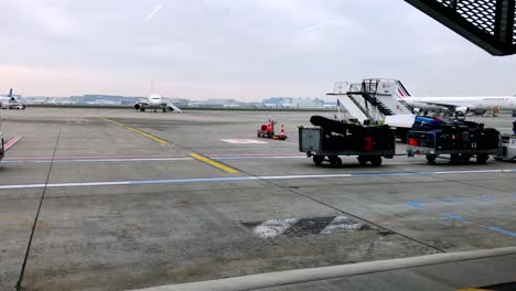 Busy-tarmac-view-of-workers-hauling-luggage-at-the-Toulouse-airport-in-Blagnac,-France