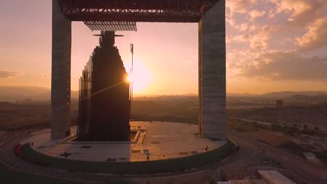 Slow-motion-clip-of-a-drone-flying-through-'Manto-de-MarÃ­a'-monument,-against-an-amazing-sunset-during-the-golden-hour,-in-Barquisimeto,-Venezuela