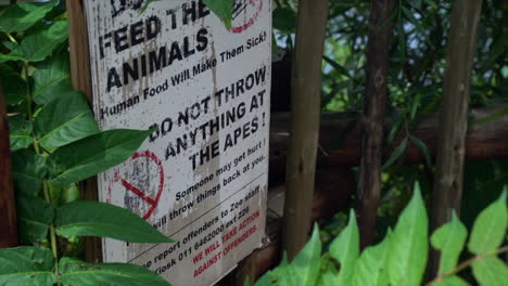 Do-not-feed-the-animals-signage-at-zoo,-slow-full-high-angled-panning-shot-left-to-right