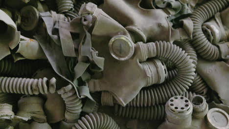 A-Pile-Of-Gas-Masks-On-The-floor-Inside-The-Abandoned-School-In-Chernobyl-Exclusion-Zone,-Ukraine