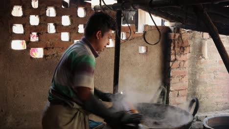 Rural-Indian-man-dyeing-cotton-cloth-into-colored-boiling-water,-small-scale-cotage-industry