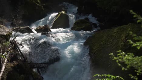 Wasserfall-Rauscht-über-Moosige-Felsen-Aus-Einem-Blauen-Gebirgsfluss