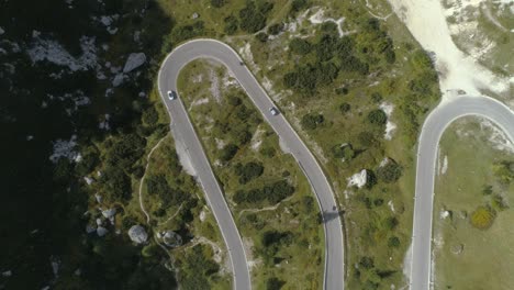 Vista-Aérea-De-Aves-Siguiendo-Un-Automóvil-En-Una-Carretera-De-Montaña-En-Los-Dolomitas-Italianos