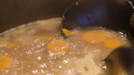 Close-up-shot-of-carrots-boiling-in-a-creamy-pot-of-stew