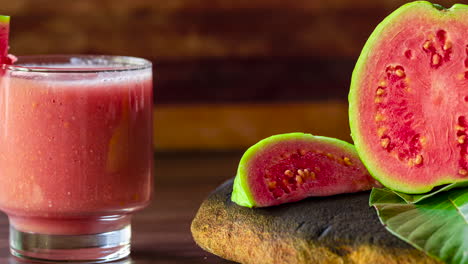 Glass-of-red-guava-juice-and-sliced-guava-slice-on-wooden-background