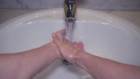 POV-Man-washing-male-hand-with-soap-and-water-under-faucet